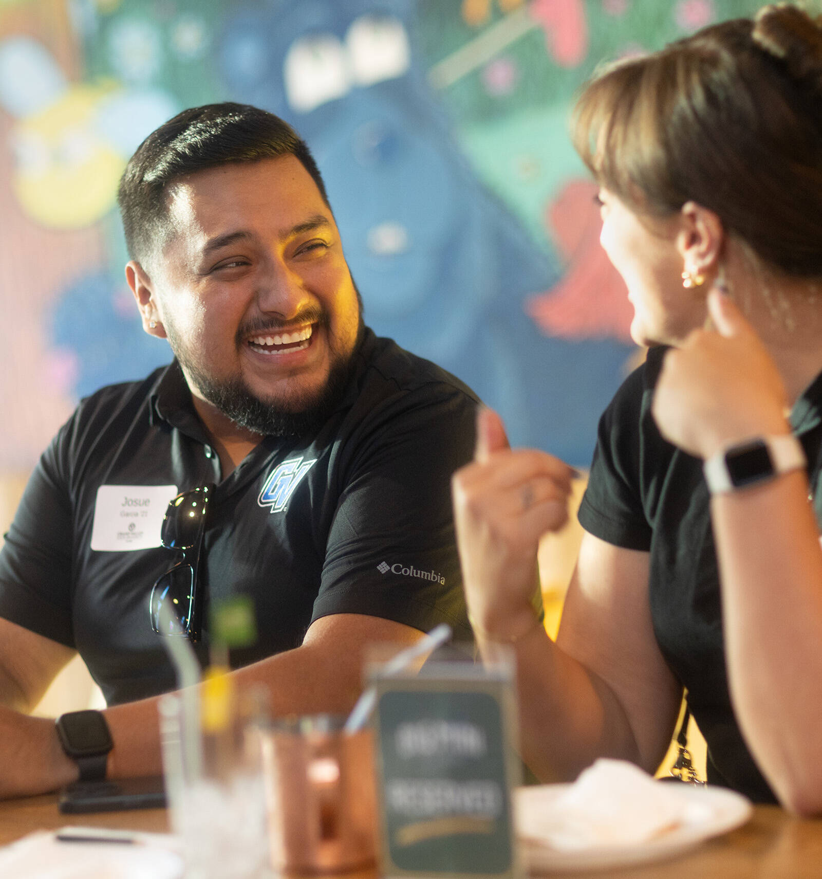 Josue, a young hispanic male, smiling at a social event